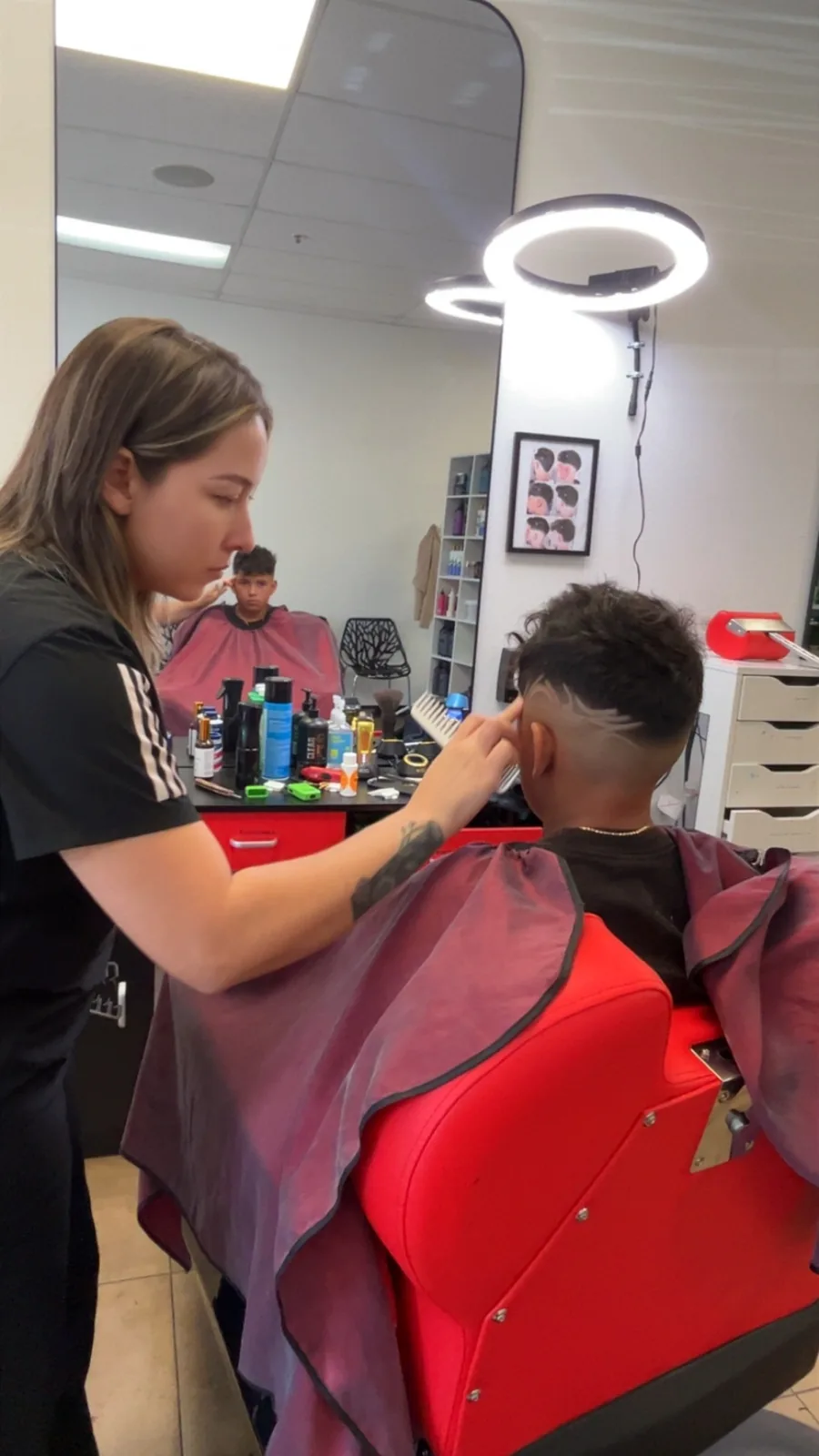 Yasmin cutting a young client's fade at the chair