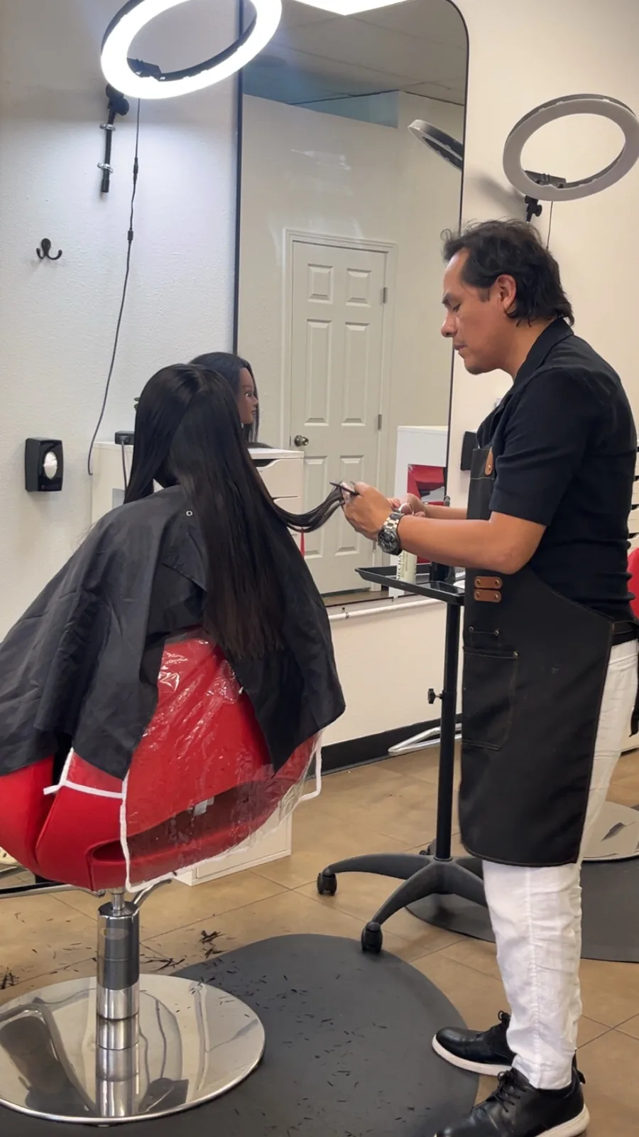 Jorge working through a client's long dark hair at the chair