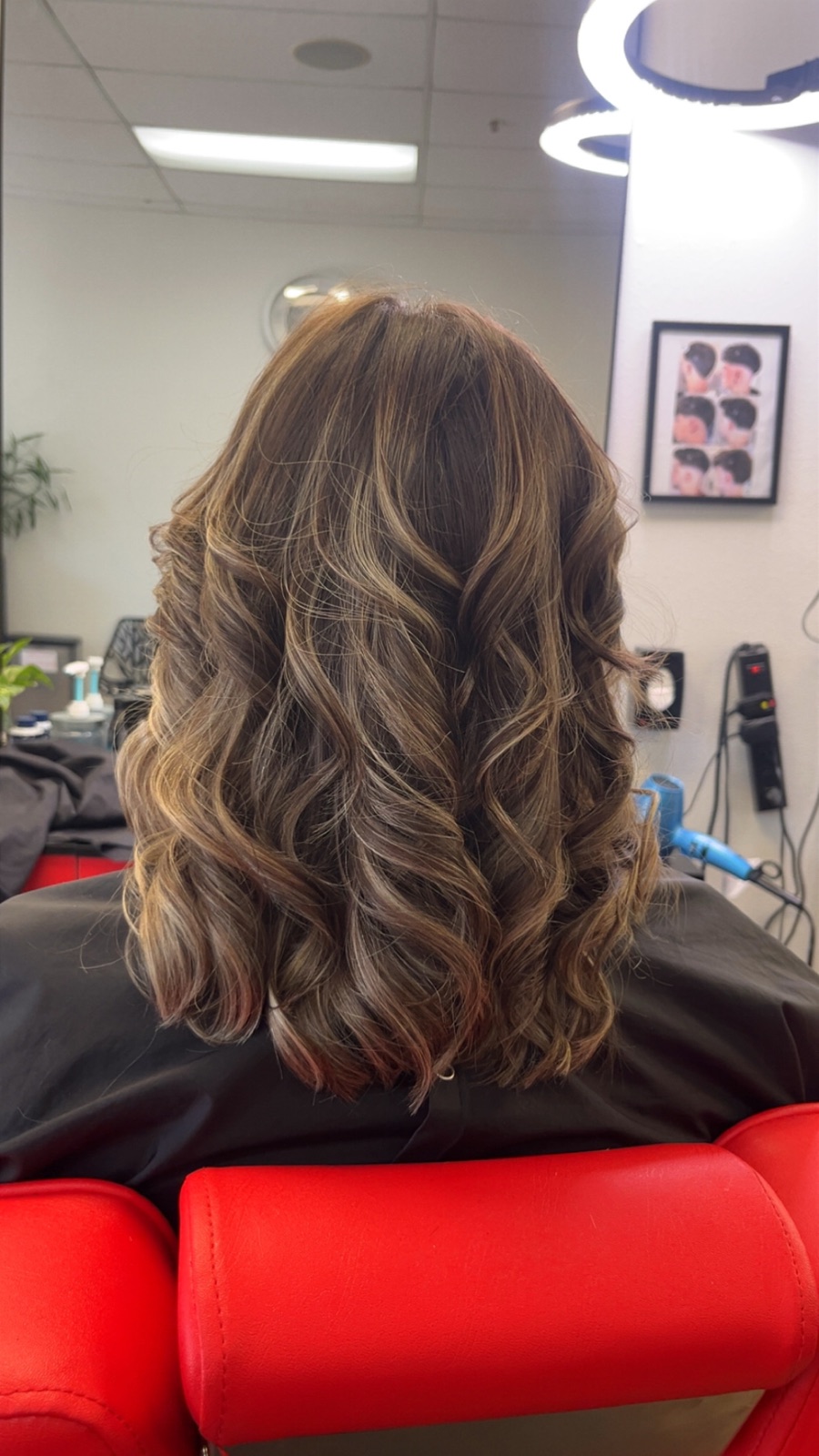 Brunette balayage with soft dimensional waves, styled at Eddy's Beauty Salon