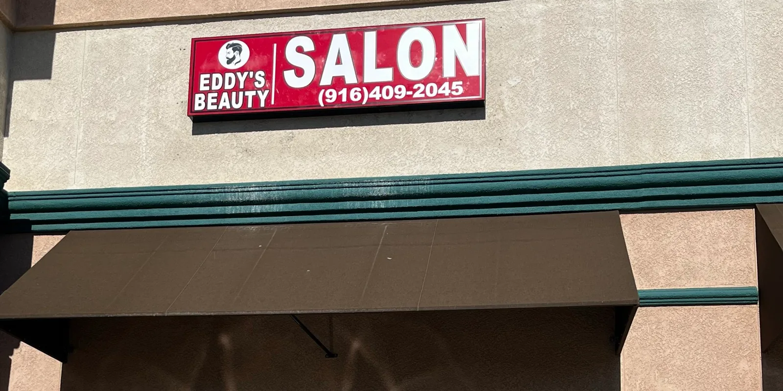 The red Eddy's Beauty Salon sign above the Suite 500 entrance at 155 Joiner Parkway in Lincoln