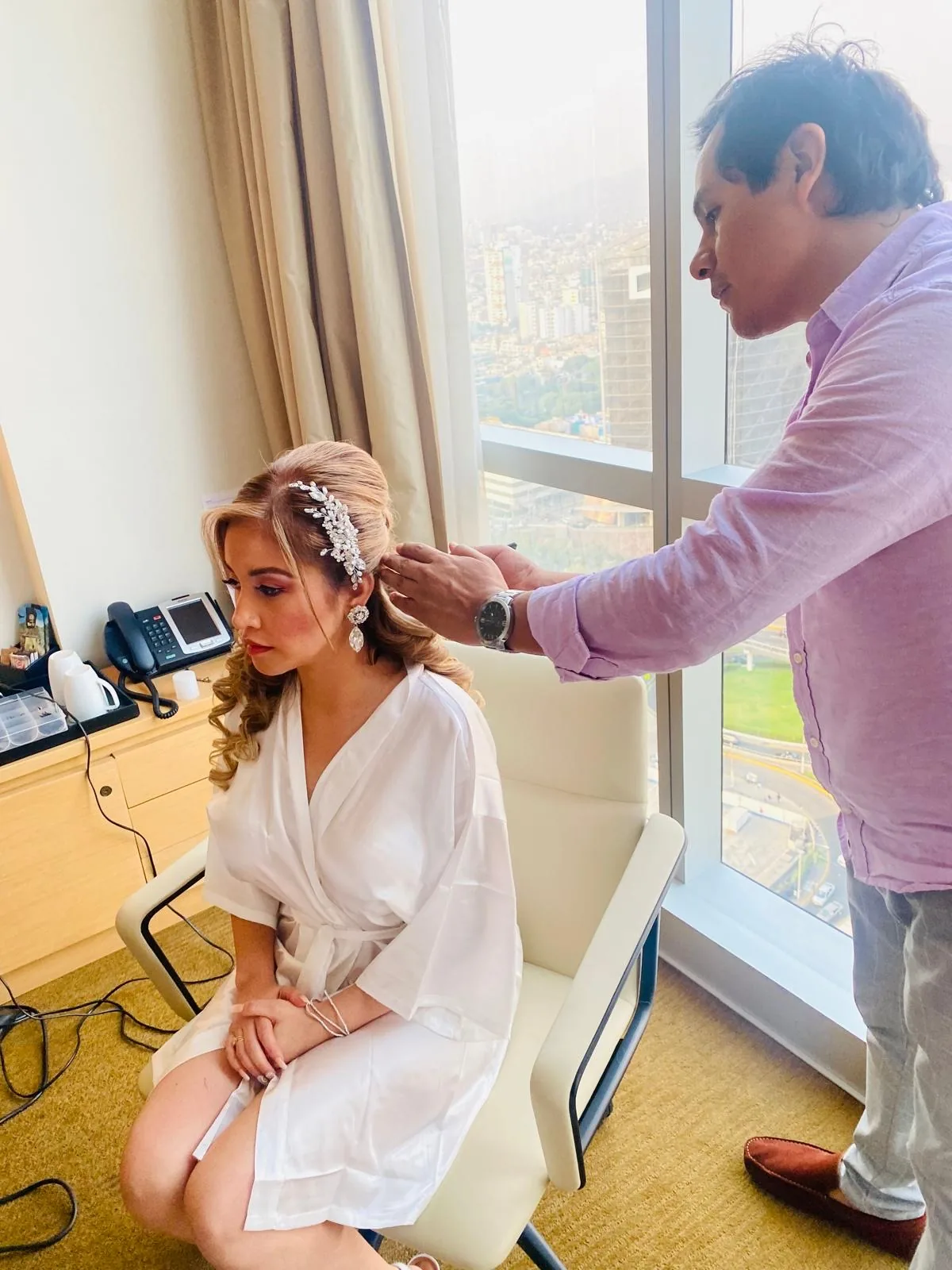Jorge setting a bridal updo with a jeweled hairpiece